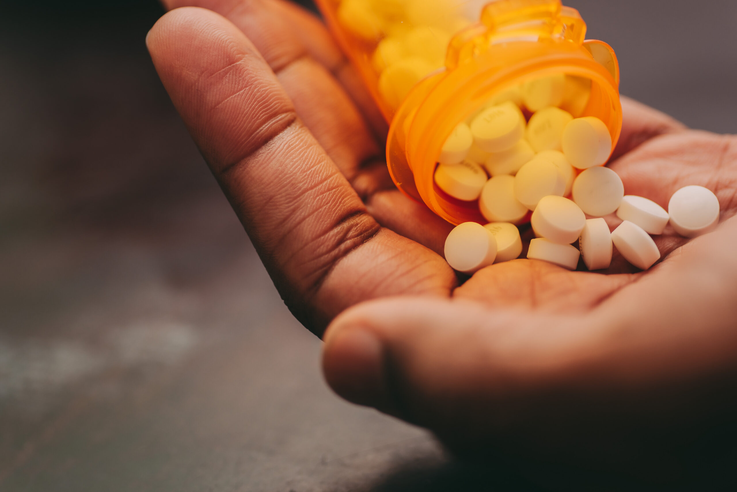 pills on hand with orange pill bottle 2026 03 09 06 03 26 utc